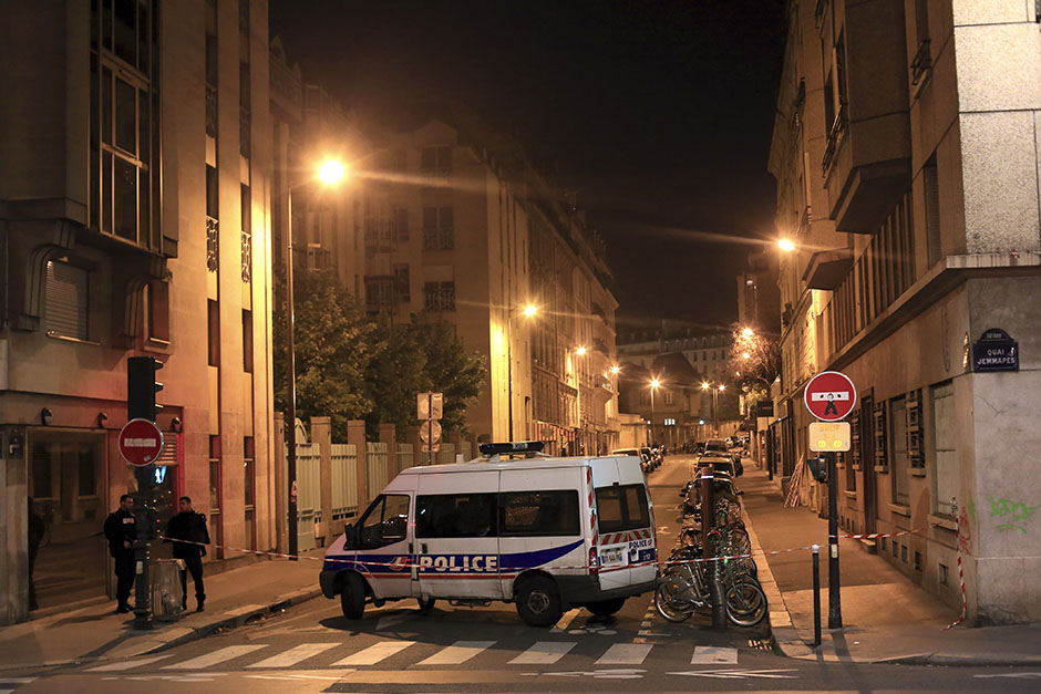 Police officers stand in a street next to Le Carillon, a bar-cafe where people were killed and several gravely injured, according to the prosecutor, in Paris, Saturday, Nov. 14, 2015. A series of attacks targeting young concert-goers, soccer fans and Parisians enjoying a Friday night out at popular nightspots killed over 100 people in the deadliest violence to strike France since World War II. (AP Photo/Thibault Camus)